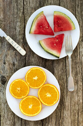 Draufsicht auf eine Orange und eine Wassermelone, die in einem Teller auf einem Holztisch serviert werden - CAVF46157