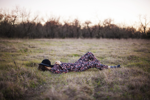 Frau in voller Länge auf einer Wiese liegend, lizenzfreies Stockfoto
