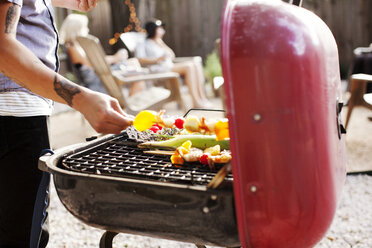 Midsection of man barbecuing in yard - CAVF46283