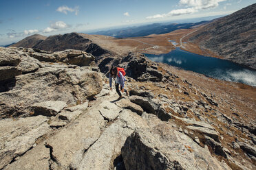 Weiblicher Wanderer beim Bergsteigen an einem sonnigen Tag - CAVF46361