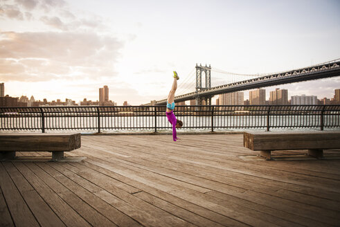 Frau macht Handstand auf der Promenade vor der Manhattan-Brücke - CAVF46452