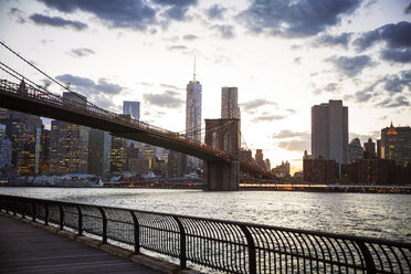 Brooklyn bridge over East River in city against sky - CAVF46461