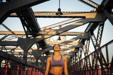 Front view of woman relaxing while standing on bridge - CAVF46518