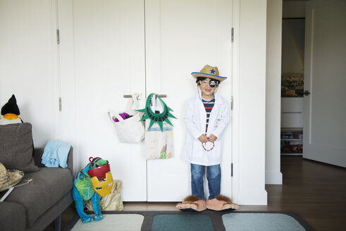 Glücklicher Junge im Kostüm, der zu Hause vor einem Schrank steht - CAVF46573