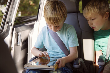 Junge benutzt Tablet-Computer im Auto sitzend - CAVF46602