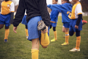 Fußballspieler dehnen die Beine beim Aufwärmen auf dem Spielfeld - CAVF46629