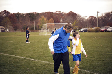 Trainer tröstet Fußballspieler auf dem Feld beim Spiel - CAVF46635