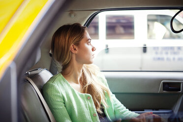 Portrait of woman sitting in taxi at city - CAVF46781