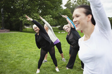 Senior women with trainer exercising at park - MASF06796