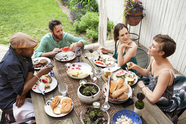 High angle view of friends at table in yard - CAVF46866