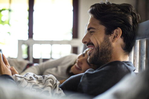 Glückliches Paar auf dem Bett liegend zu Hause - CAVF47053