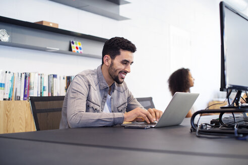 Kollegen bei der Arbeit am Schreibtisch im Büro - CAVF47167