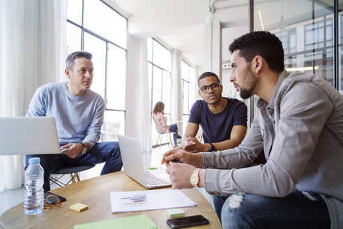 Männliche Kollegen diskutieren in einer Besprechung im Büro - CAVF47187