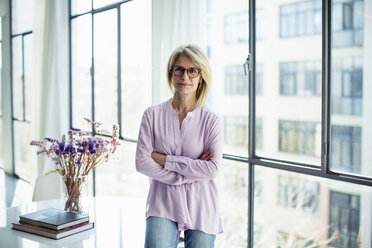 Portrait of businesswoman standing by window in office - CAVF47208