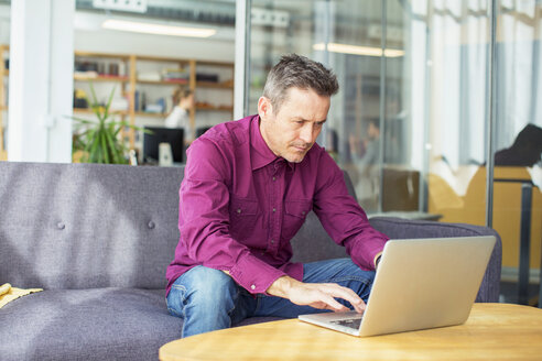 Geschäftsmann mit Laptop im Büro - CAVF47240