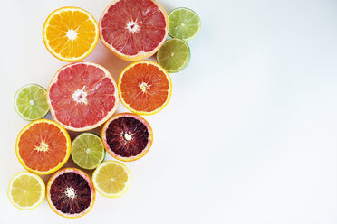 Overhead view of various chopped citrus fruits on paper - CAVF47278