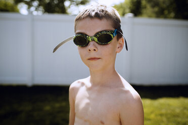 Nahaufnahme eines Jungen mit Schwimmbrille auf einem Feld - CAVF47291