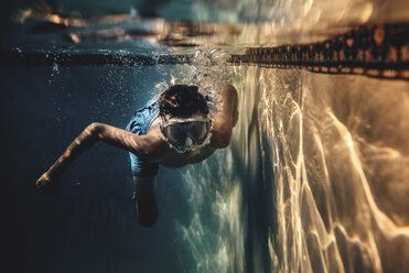 Unbekümmerter Junge mit Schwimmbrille im Schwimmbad - CAVF47310