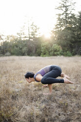 High angle view of woman practicing yoga posture at field - CAVF47383