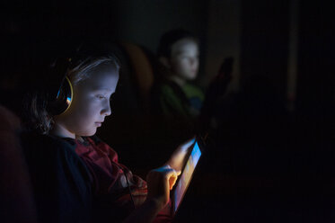 Junge benutzt Tablet-Computer in der Dunkelkammer zu Hause - CAVF47456