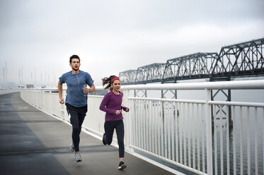 Determined male and female athletes running on Bay Bridge - CAVF47470