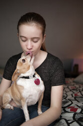 Chihuahua licking girl at home - CAVF47484