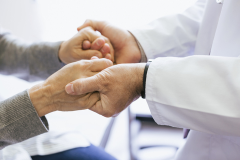 Nahaufnahme eines Arztes, der die Hände eines älteren Patienten hält, lizenzfreies Stockfoto