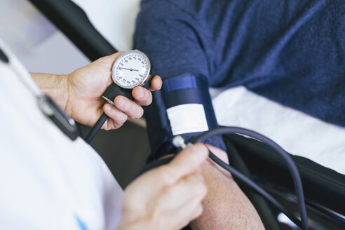 Nahaufnahme eines Arztes, der den Blutdruck eines Patienten im Krankenhaus überprüft - CAVF47524