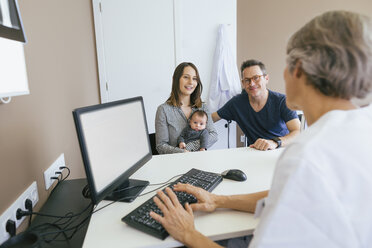 Happy family discussing with doctor at medical clinic - CAVF47541