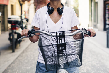 Midsection of woman holding handlebar of bicycle on street - CAVF47646