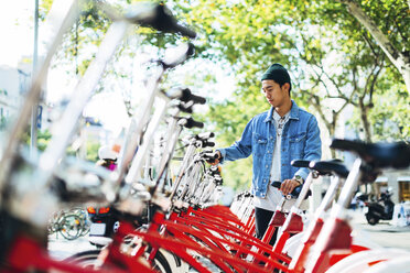 Mann mietet Fahrrad auf der Straße - CAVF47697