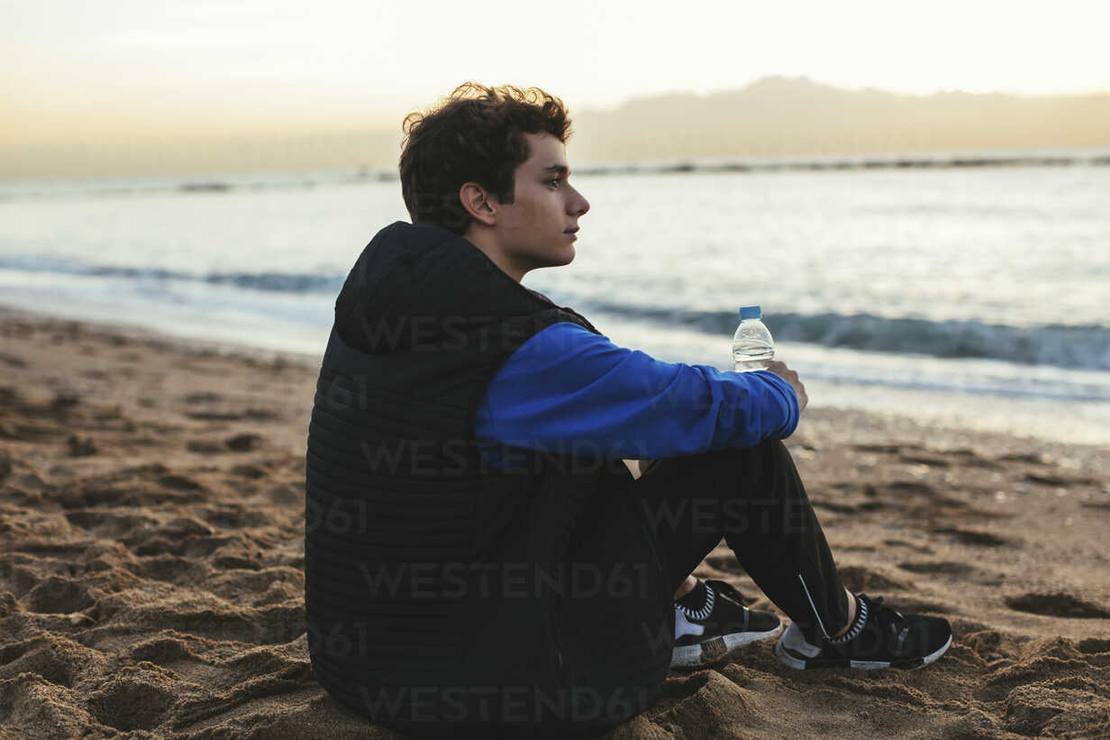 Teen Boy On Beach Holding Water Bottle High-Res Stock Photo - Getty Images