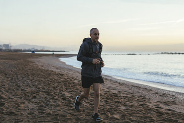 Mann joggt am Strand gegen den Himmel bei Sonnenuntergang - CAVF47741