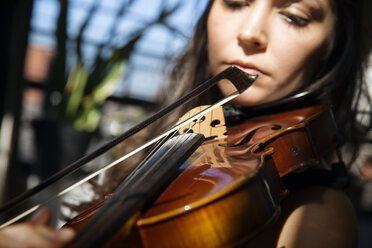 Close-up of woman playing violin at home - CAVF47775