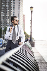 Thoughtful man standing on promenade against building in city - CAVF47825