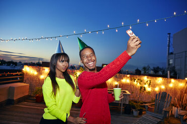 Glückliche Freunde nehmen Selfie durch Handy auf Gebäude Terrasse auf Geburtstagsparty - CAVF47892