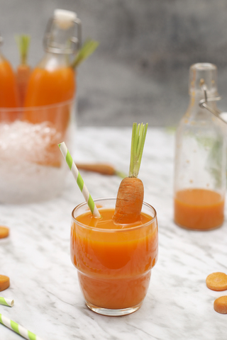 Refreshing carrot juice on marble stock photo