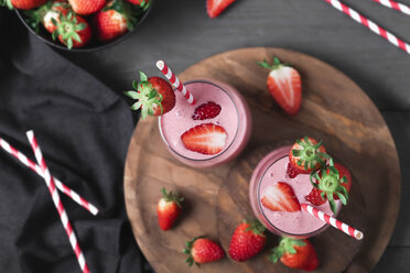Glasses of strawberry smoothie and strawberries on dark wood - RTBF01197