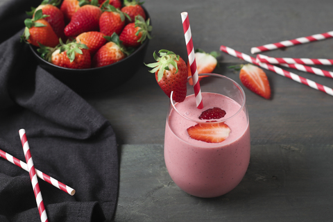 Glasses of strawberry smoothie and strawberries on dark wood stock photo