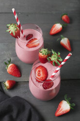 Glasses of strawberry smoothie and strawberries on dark wood - RTBF01199
