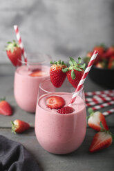 Glasses of strawberry smoothie and strawberries on dark wood - RTBF01201