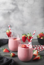 Gläser mit Erdbeer-Smoothie und Erdbeeren auf dunklem Holz - RTBF01202