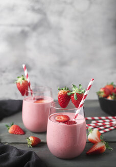 Glasses of strawberry smoothie and strawberries on dark wood - RTBF01202