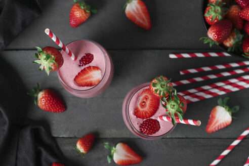 Gläser mit Erdbeer-Smoothie und Erdbeeren auf dunklem Holz - RTBF01204