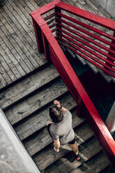 Athlete walking up stairs outdoors - DAWF00663