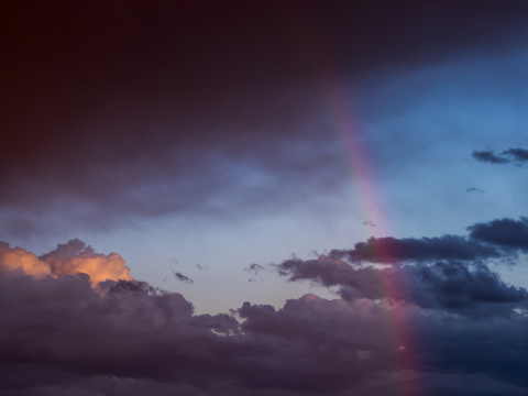 Austria, Hoersching, dark clouds after thunderstorm and rainbow stock photo