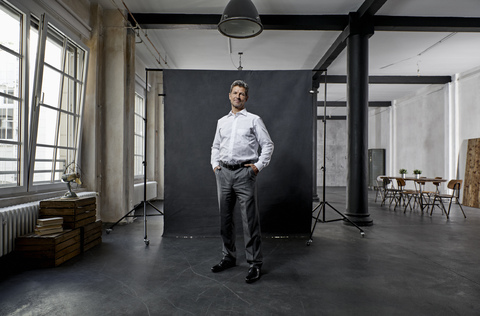Portrait of mature businessman in front of black backdrop in loft stock photo