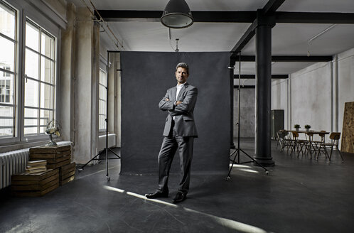 Porträt eines reifen Geschäftsmannes vor einem schwarzen Hintergrund in einem Loft - PDF01567