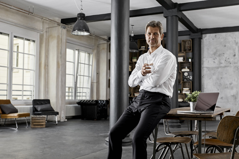 Portrait of mature businessman in loft office stock photo