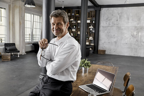 Portrait of smiling mature businessman in loft office - PDF01594